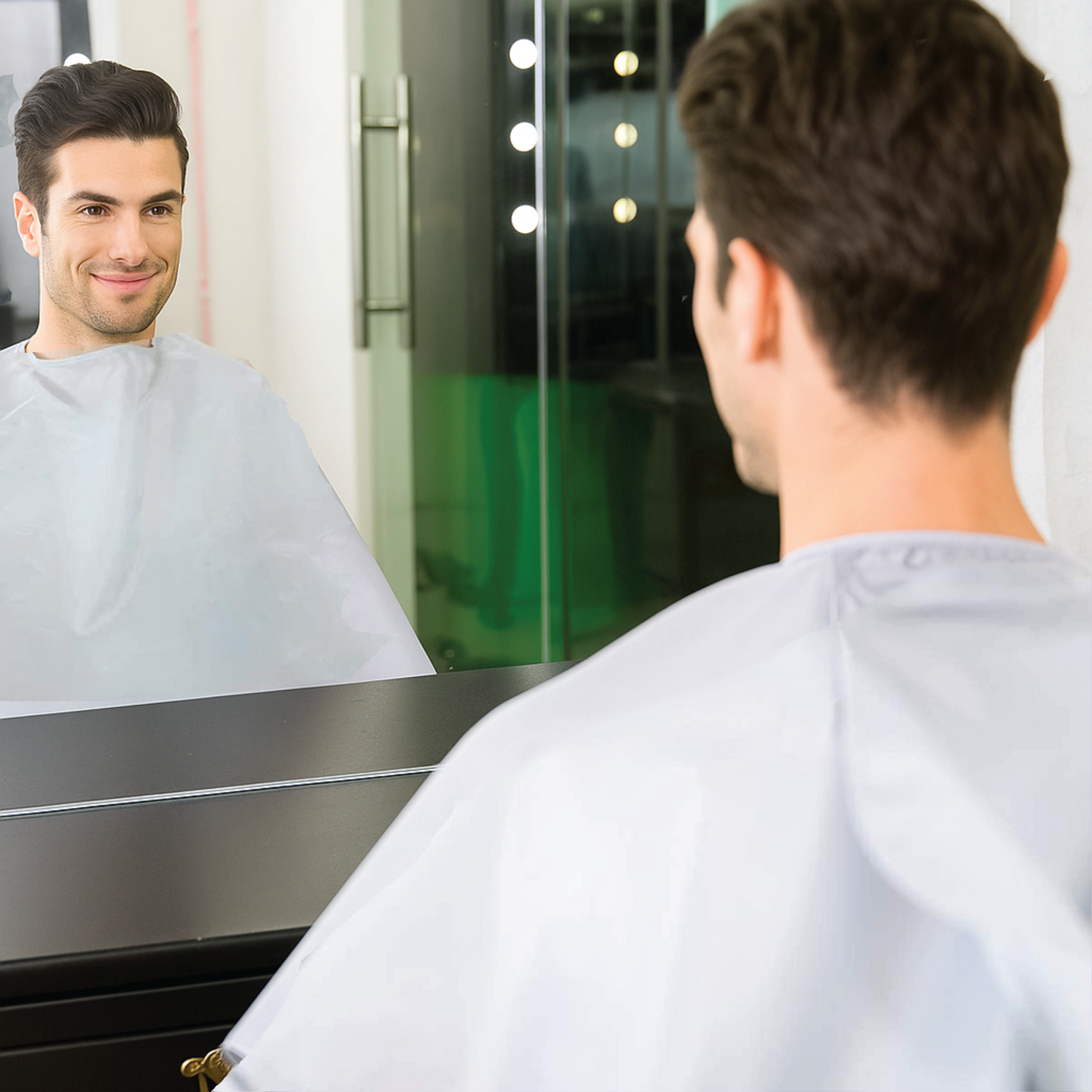Man looking at himself in a mirror wearing a salon apron