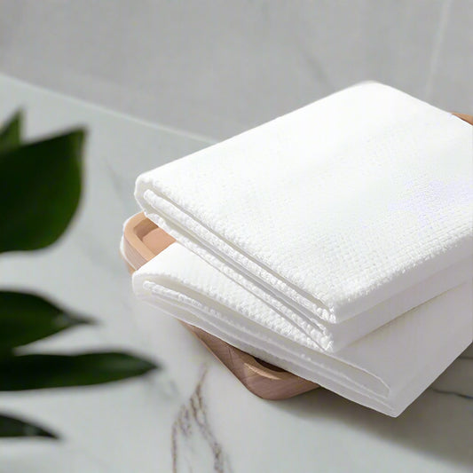 A stack of white disposable body towels.