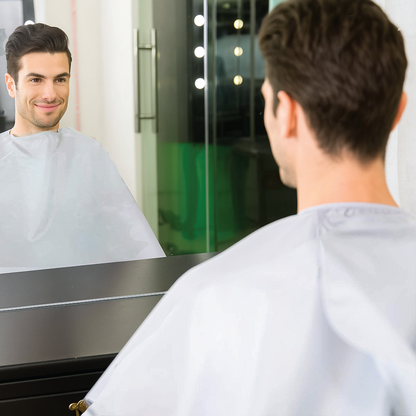 Man looking at himself in a mirror wearing a salon apron 